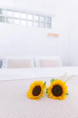three yellow sunflowers are sitting on a table at Ratchada Retreat Boutique Villa 1 in Bangkok