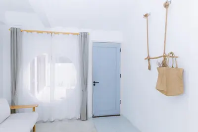 a white room with a white door and a couch at Ratchada Retreat Boutique Villa 1 in Bangkok