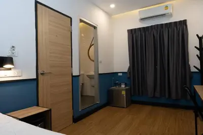 a room with a bed and a bathroom with a mirror at Malades House in Bangkok