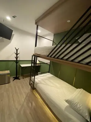 a bedroom with two bunk beds and a desk at Malades House in Bangkok