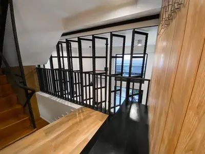 a staircase with black metal railings and a wooden wall at Livinn91 Hotel in Bangkok