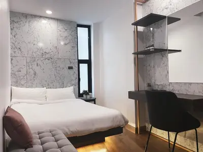 a bedroom with a bed and a desk and a chair at Livinn91 Hotel in Bangkok