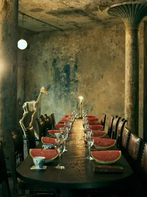 a long table with wine glasses and a giraffe on the wall at The Mustang Blu in Bangkok