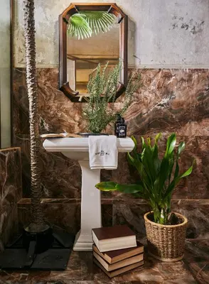 a bathroom with a sink and a mirror and a plant at The Mustang Blu in Bangkok