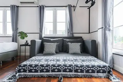 a bedroom with a bed and two windows at MIQ Asoke202 Pool Villa - Asoke BTS 16 Pax in Bangkok