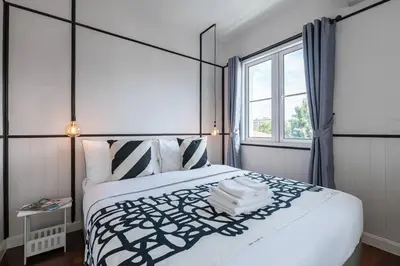 a bedroom with a large bed and a window at MIQ Asoke202 Pool Villa - Asoke BTS 16 Pax in Bangkok