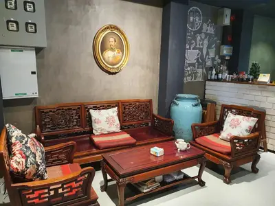 a living room with wooden furniture and a table and chairs at Baan Wualamphong บ้านวัวลำพอง in Bangkok
