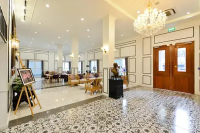 a woman is standing in a lobby with a painting at Villa De Pranakorn in Bangkok