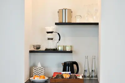 a shelf with a coffee maker and other items on it at Villa De Pranakorn in Bangkok