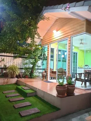 a house with a patio with grass and plants at Papermoon Guesthouse in Bangkok