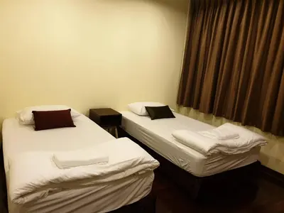 two twin beds in a room with a window at Papermoon Guesthouse in Bangkok