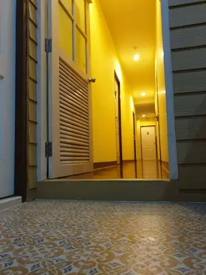 a hallway of a house with a door and a tile floor at Papermoon Guesthouse in Bangkok