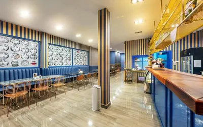 a restaurant with blue walls and tables and chairs at Happy Station Bangkok in Bangkok