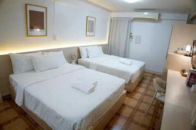 a hotel room with two beds with white sheets at ปลื้มจิต อพาร์ทเม้น บางใหญ่ in Nonthaburi