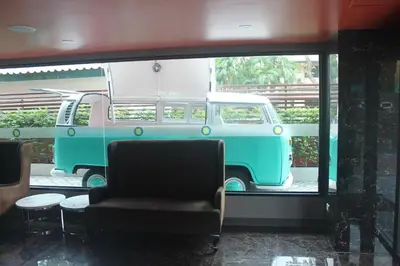 a green and white van parked in a room with a chair at H-District Boutique Poshotel in Bangkok
