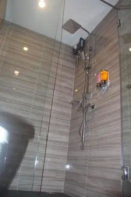 a shower in a bathroom with a glass wall at H-District Boutique Poshotel in Bangkok
