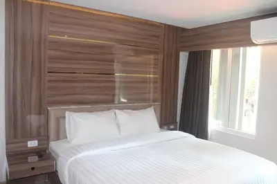 a bedroom with a large white bed with a window at H-District Boutique Poshotel in Bangkok