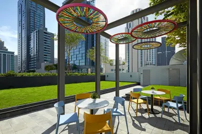 a patio with tables and chairs and umbrellas at lyf Sukhumvit 8 Bangkok in Bangkok