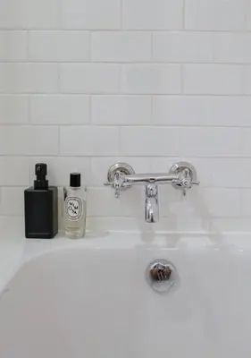 a white sink with a bottle of soap and a soap dispenser at Marlowe-Tony's home in Bangkok