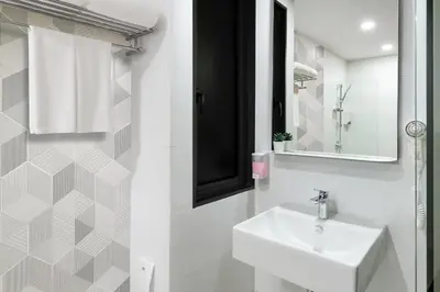 a white bathroom with a sink and a mirror at Hotel Z zpaze in Bangkok