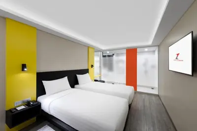 a hotel room with two beds and a painting on the wall at Hotel Z zpaze in Bangkok