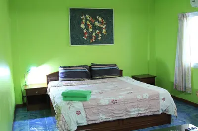 a bedroom with a bed with green walls at Swan inn 2 Nana in Bangkok