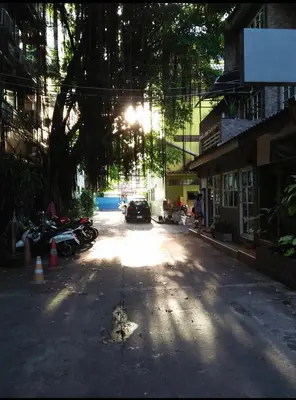 a street with a car parked on the road at Swan inn 2 Nana in Bangkok