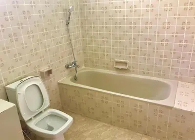a bathroom with a toilet and a bath tub and a sink at Swan inn 2 Nana in Bangkok