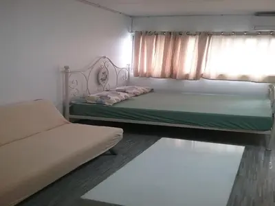a bedroom with a bed and a couch and a window at Impact Don Mueang Bangkok Guest House For 3 Pax in Nonthaburi