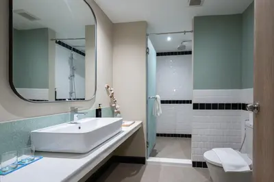 a bathroom with a sink and a mirror at The Cotton Saladaeng Hotel in Bangkok