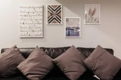 a black leather couch with pillows in a living room at S1 Large Duplex Silom 3 Beds, Full Kitchen WIFI in Bangkok