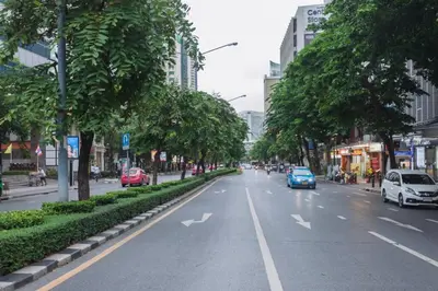 a street with cars driving down a street with trees at S1 Large Duplex Silom 3 Beds, Full Kitchen WIFI in Bangkok