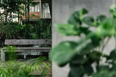a wooden bench in front of a building with plants at APT476 in Bangkok