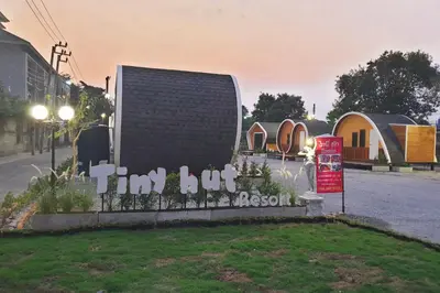 a sign that says im but in front of houses at Tiny hut resort in Bangkok