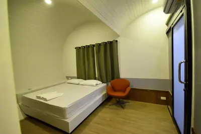 a small room with a bed and a chair at Tiny hut resort in Bangkok