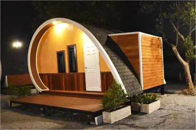 a small house with a round door and a wooden bench at Tiny hut resort in Bangkok