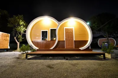 a circular house with a mirror on top of a bench at Tiny hut resort in Bangkok