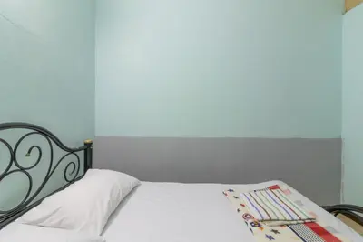 a bedroom with a white bed with a black frame at 7 Holder Guesthouse in Bangkok