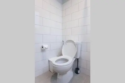 a white toilet in a bathroom with white tiles at S2 Silom Large room 4-6 guests Full kitchen WIFI in Bangkok