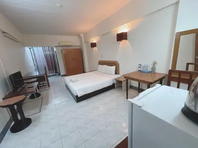 a hotel room with a bed and a desk at Win Mansion in Bangkok