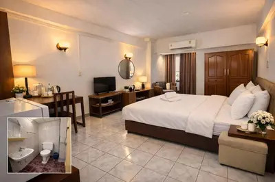 a hotel room with a large bed and a bathroom at Win Mansion in Bangkok