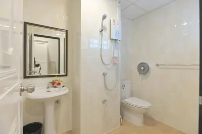 a bathroom with a shower and a toilet and a sink at Parvena Ratchada in Bangkok