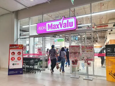 people walking in a shopping mall with a neon maxxulum sign at Popular CondoT8@IMPACT Arena in Nonthaburi
