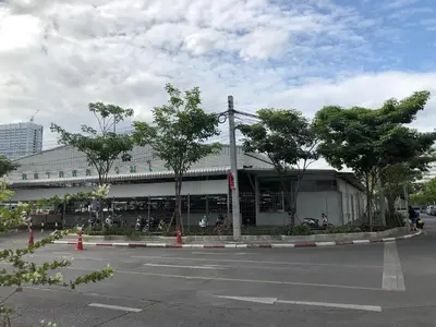 a building on a street with trees in front of it at Popular CondoT8@IMPACT Arena in Nonthaburi