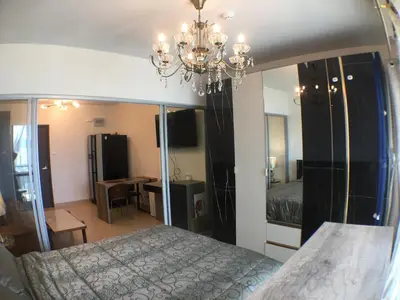 a bedroom with a bed and a chandelier at Supalai Rama9 Monthly in Bangkok