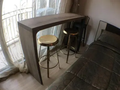 a wooden table with two stools next to a bed at Supalai Rama9 Monthly in Bangkok