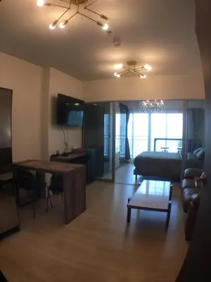 a living room with a table and a couch at Supalai Rama9 Monthly in Bangkok
