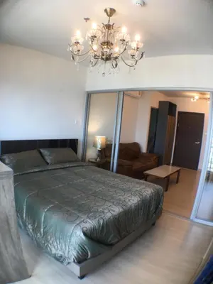 a bedroom with a bed and a chandelier at Supalai Rama9 Monthly in Bangkok
