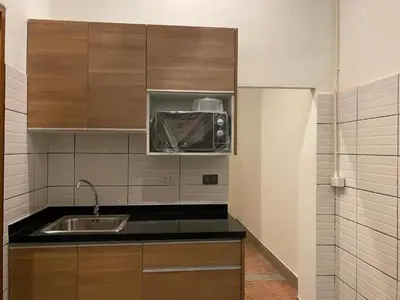 a kitchen with wooden cabinets and a sink at Taladnoi Paint House in Bangkok