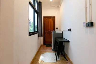 a hallway with a small table and a door at Taladnoi Paint House in Bangkok